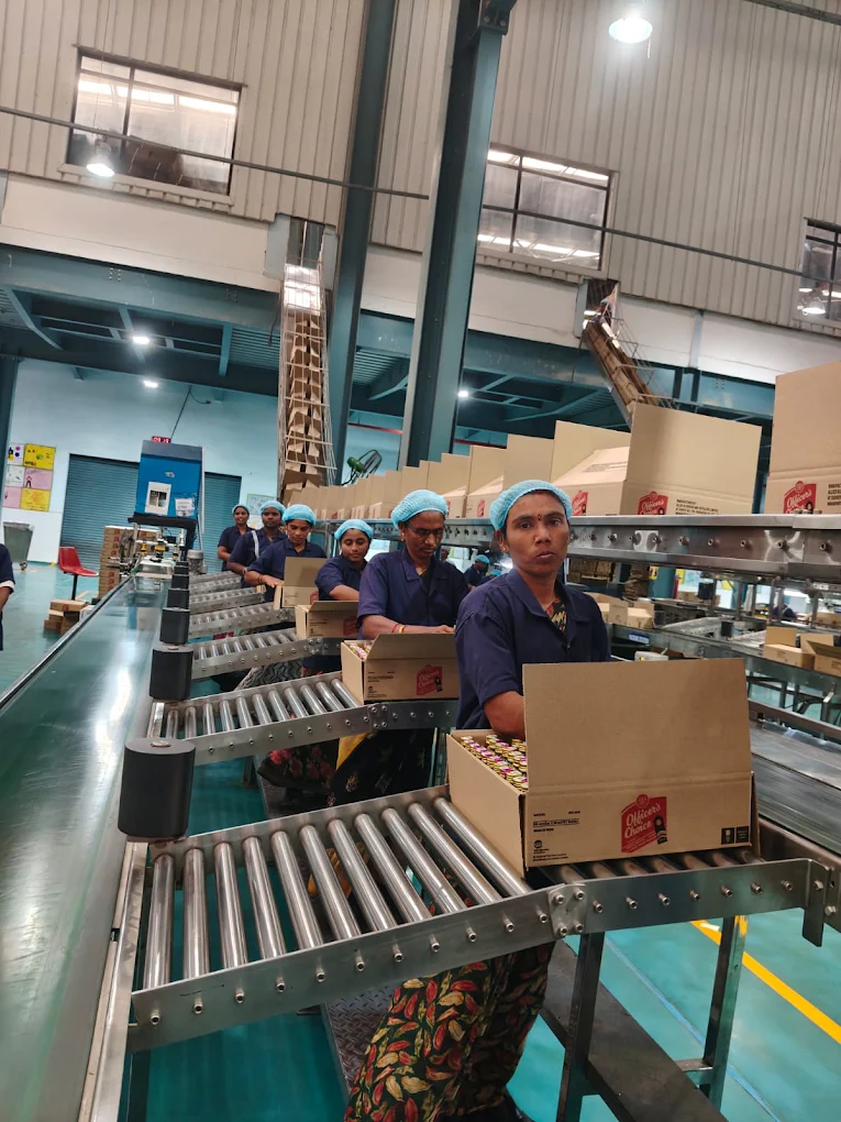 Workers handling cartons on a conveyor line
