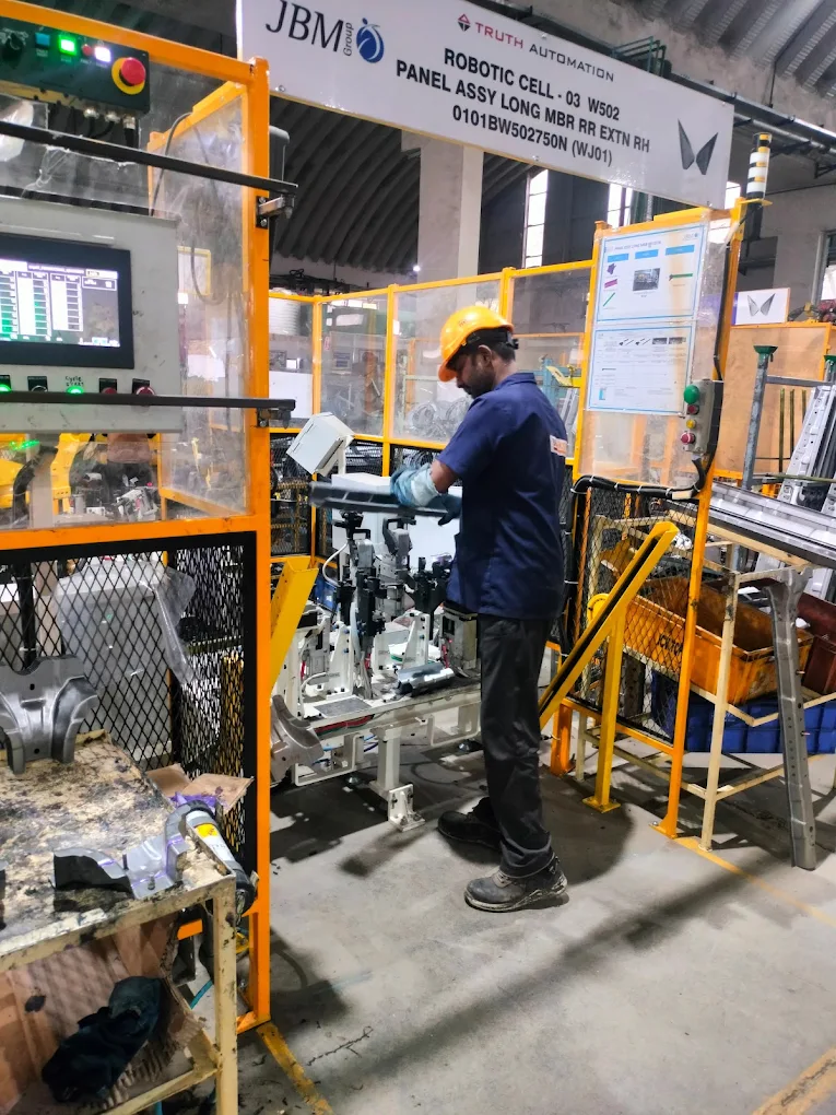 Worker operating equipment on an automotive assembly line
